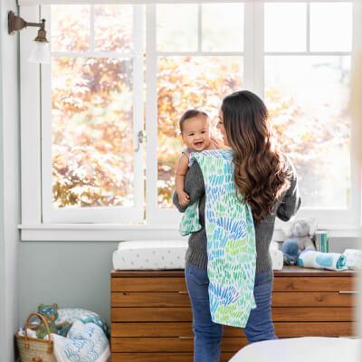 a mother holding her laughing baby in a comfortable room
